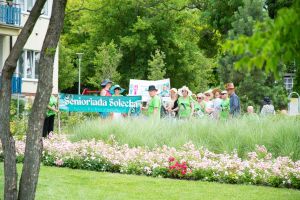 Widok seniorów przygotowujących się do przemarszu ulicami miasta
