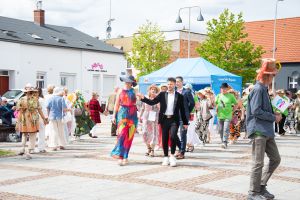 Widok seniorów oraz przedstawicieli władz miasta, którzy tańczą Poloneza